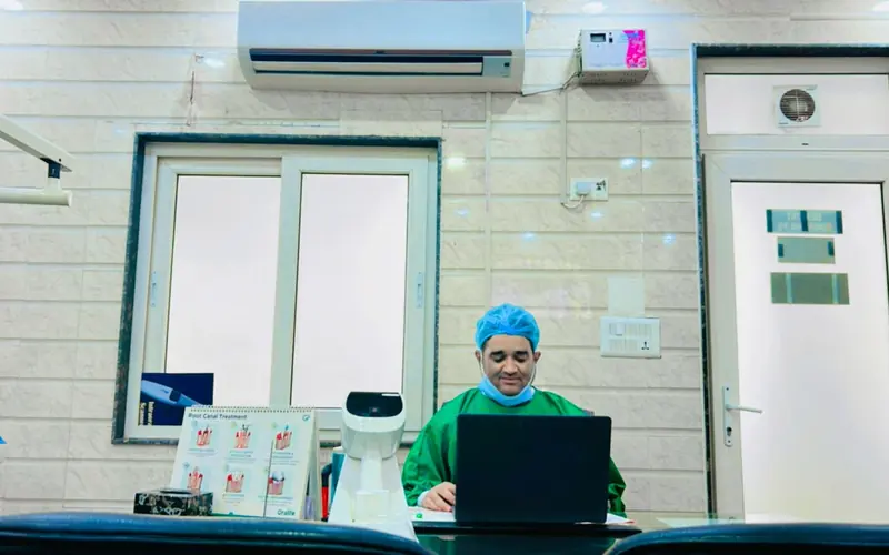 Dentist at his desk in the consultation room at Rijul's Dental, Janakpuri
